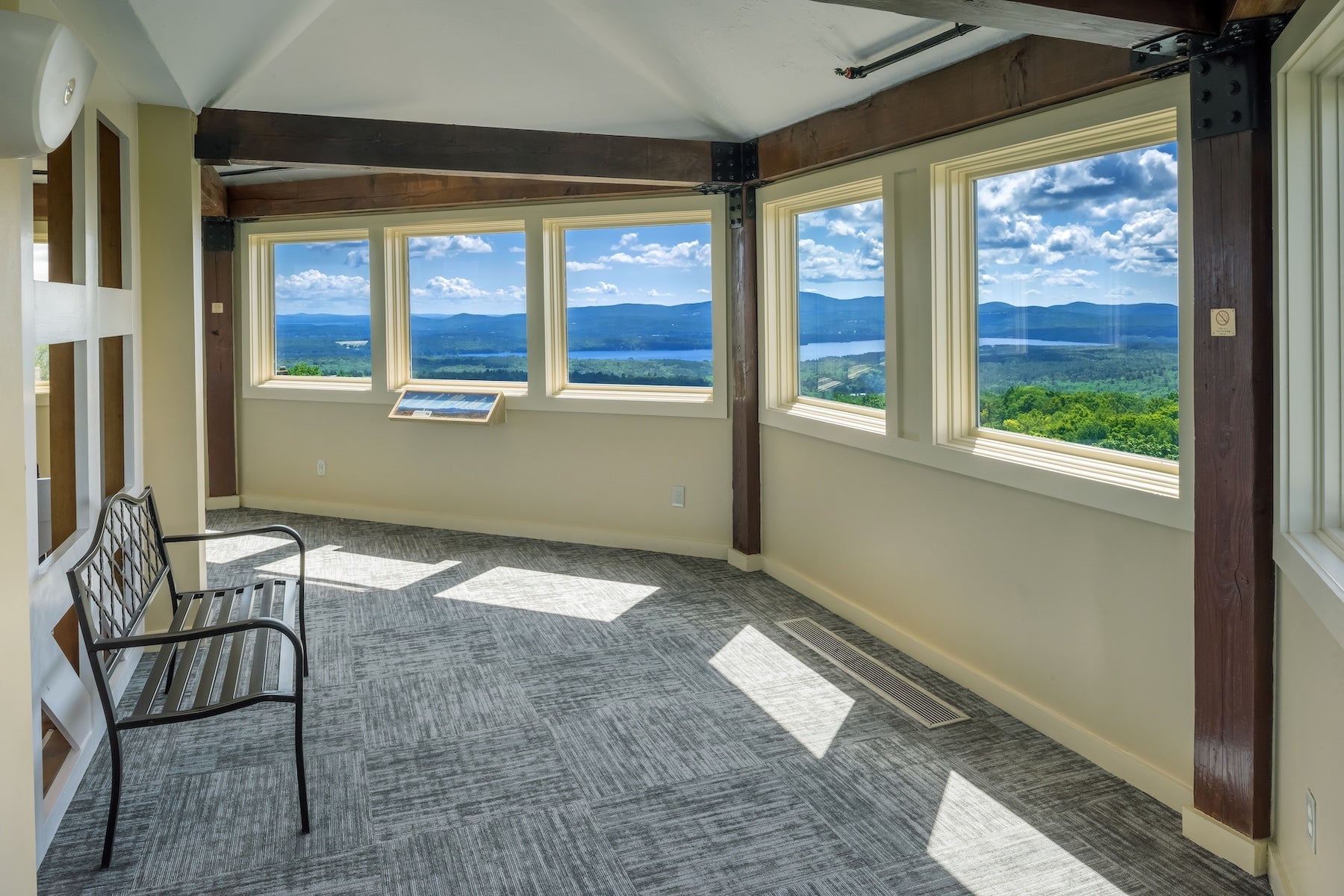 Glass-walled observation room at Steele Hill with panoramic windows over forested hills and the lake