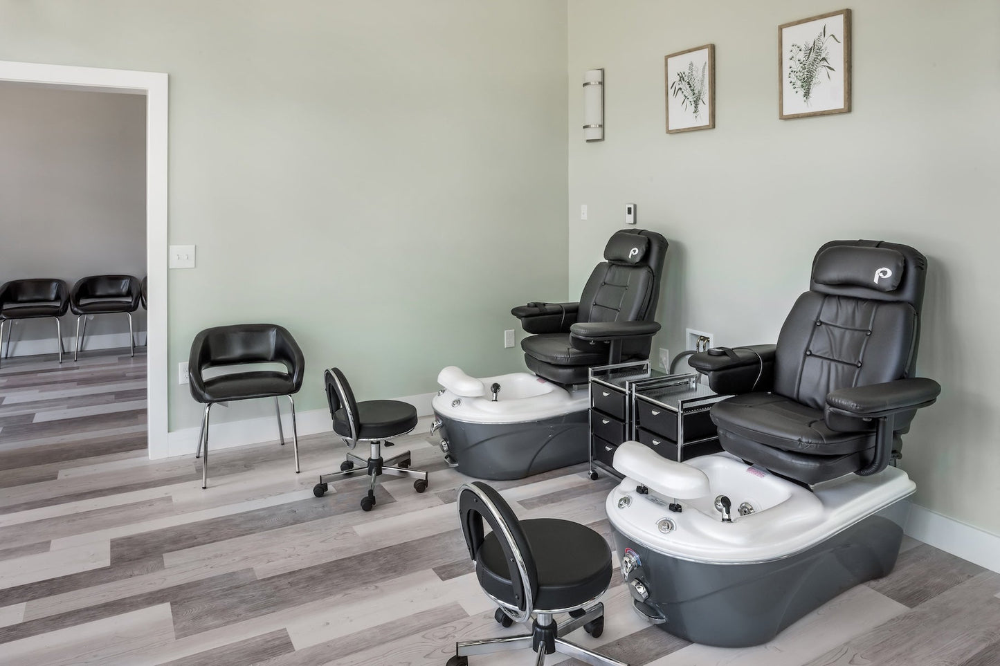 Steele Hill salon with two pedicure spa chairs, rolling stools and botanical prints