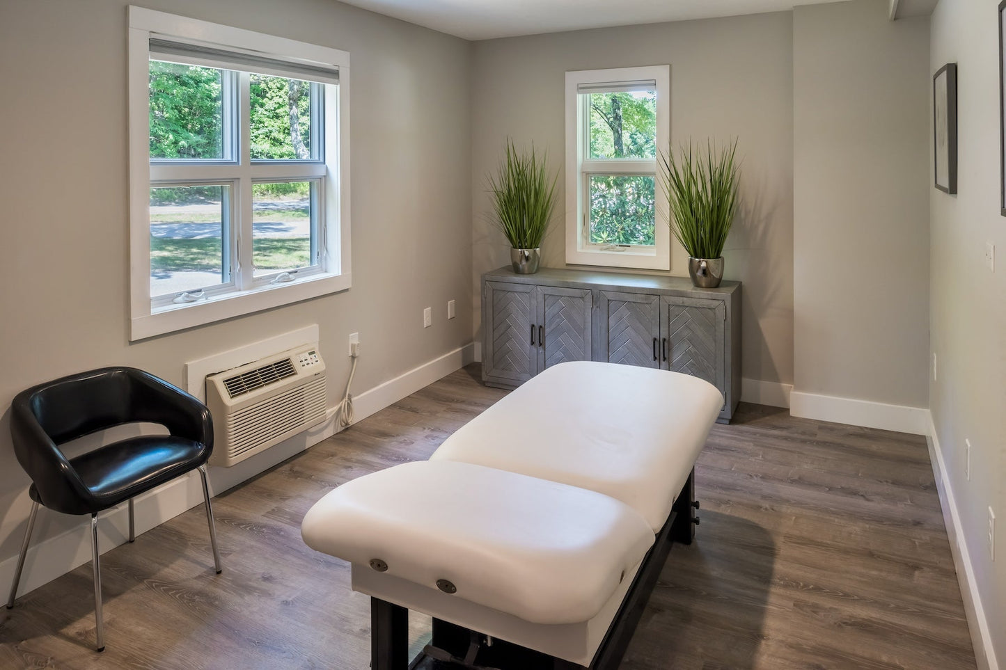 Steele Hill massage treatment room with a white table and windows onto the woods