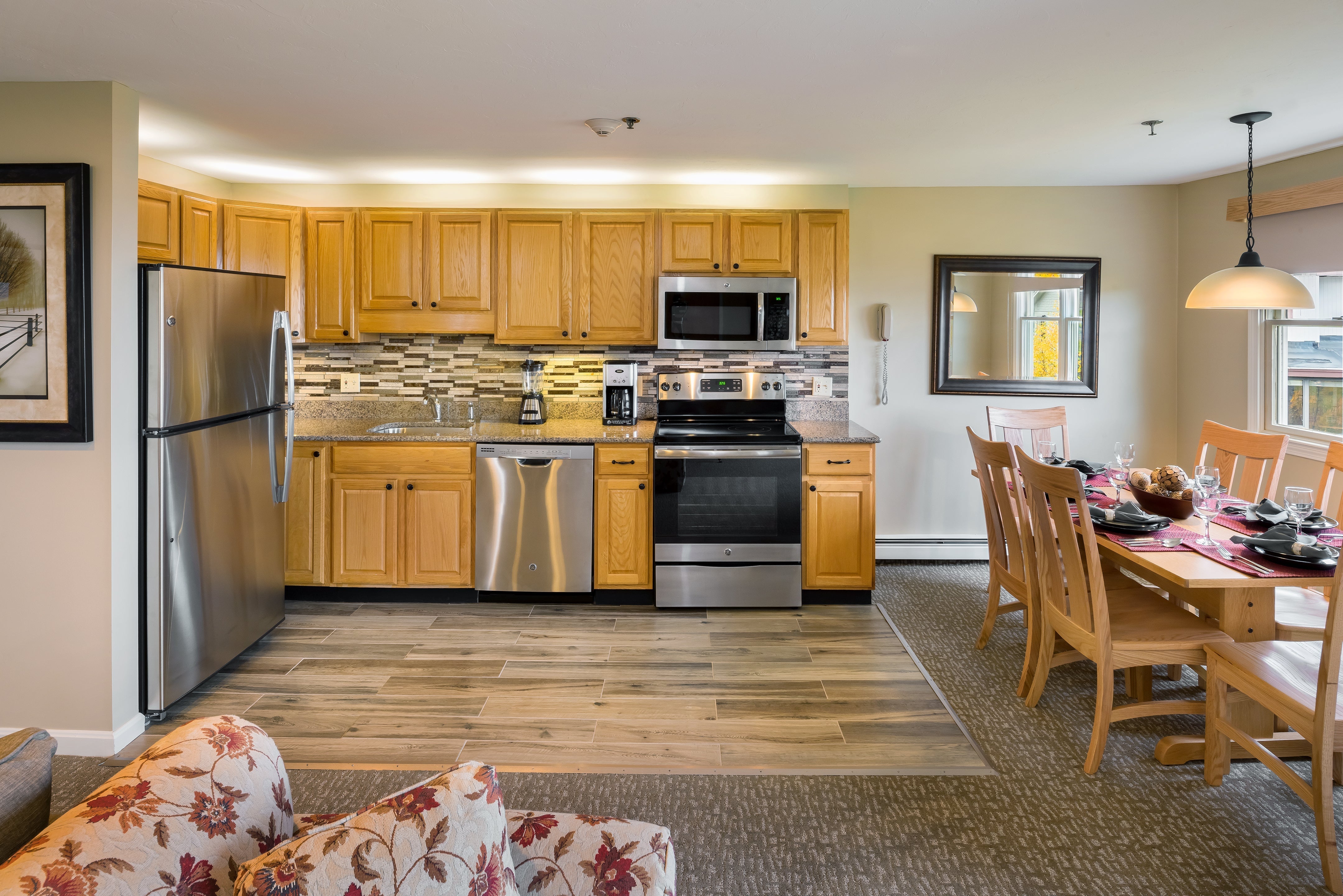 Steele Hill suite kitchen with oak cabinets and stainless appliances beside a dining table set for a meal
