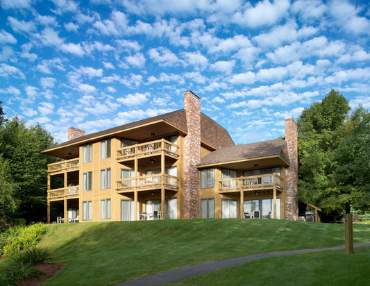 The Summit Resort's three-story cedar lodge with tiered balconies and stone chimneys on a green hillside