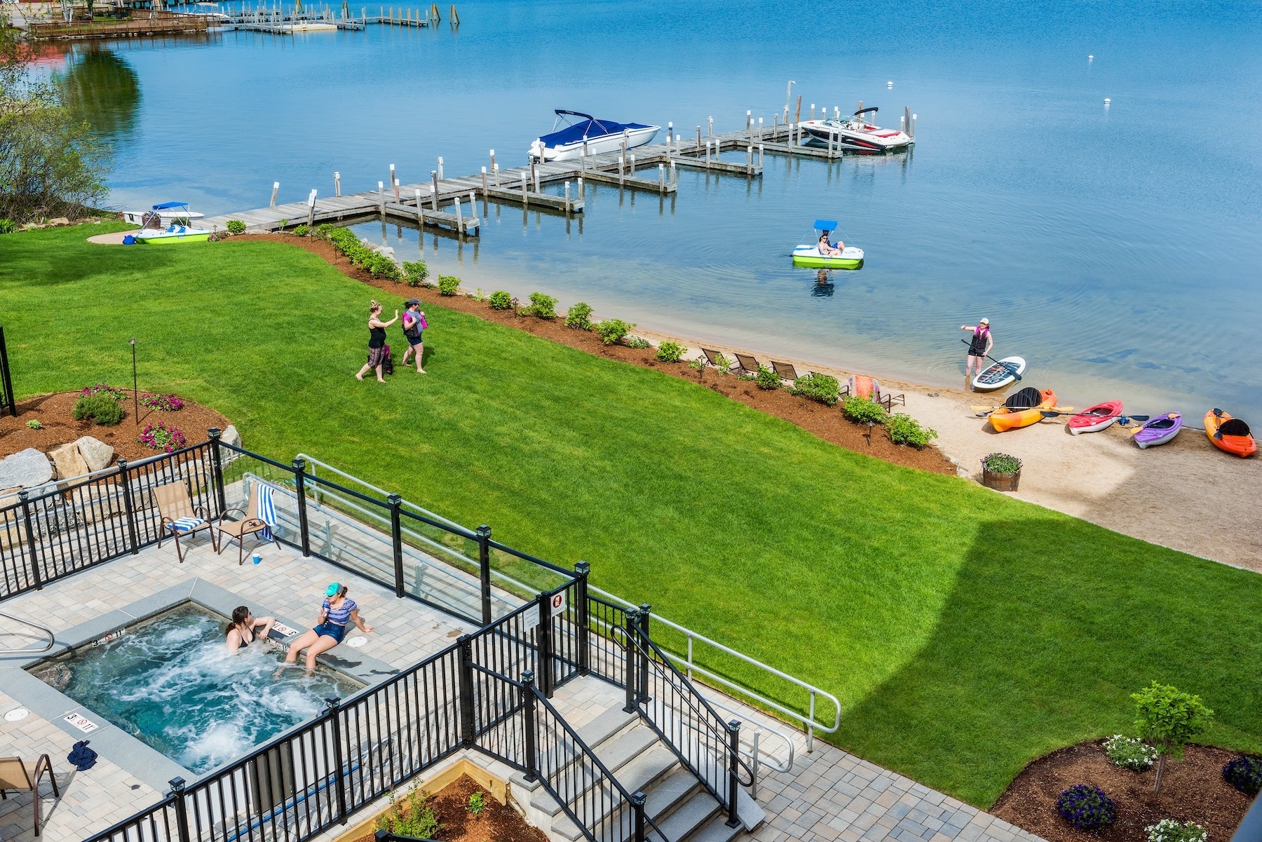 Aerial view of the Center Harbor Inn lawn, sandy beach, docks and kayaks on Lake Winnipesaukee