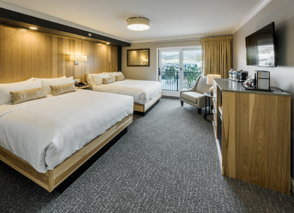 Center Harbor Inn room with two queen beds and a balcony door overlooking the marina