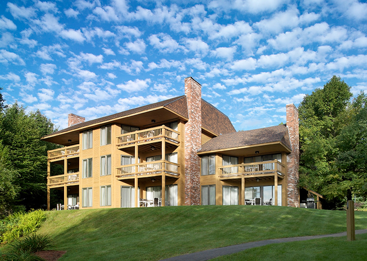 The Summit Resort's three-story cedar lodge with tiered balconies and stone chimneys on a green hillside